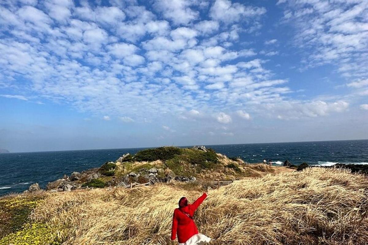 a person flying a kite on a hill with a dog