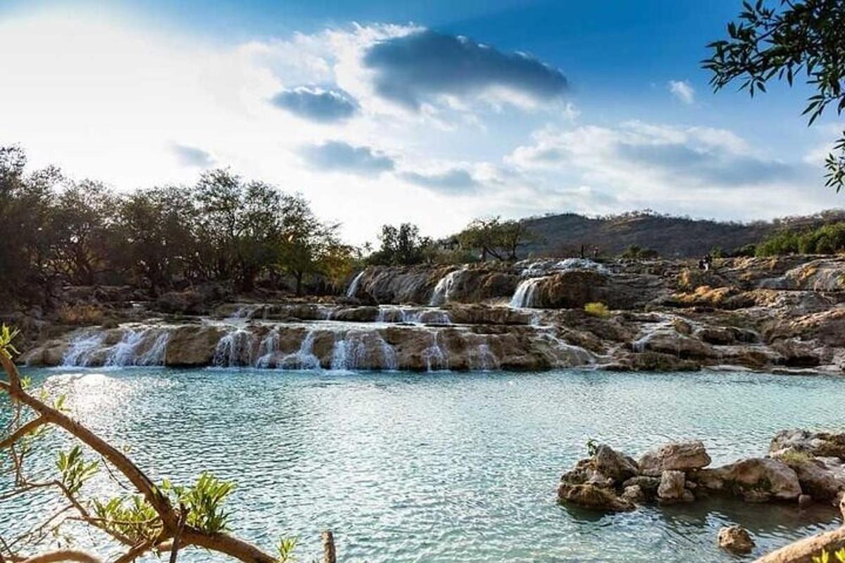a waterfall in front of a pool of water
