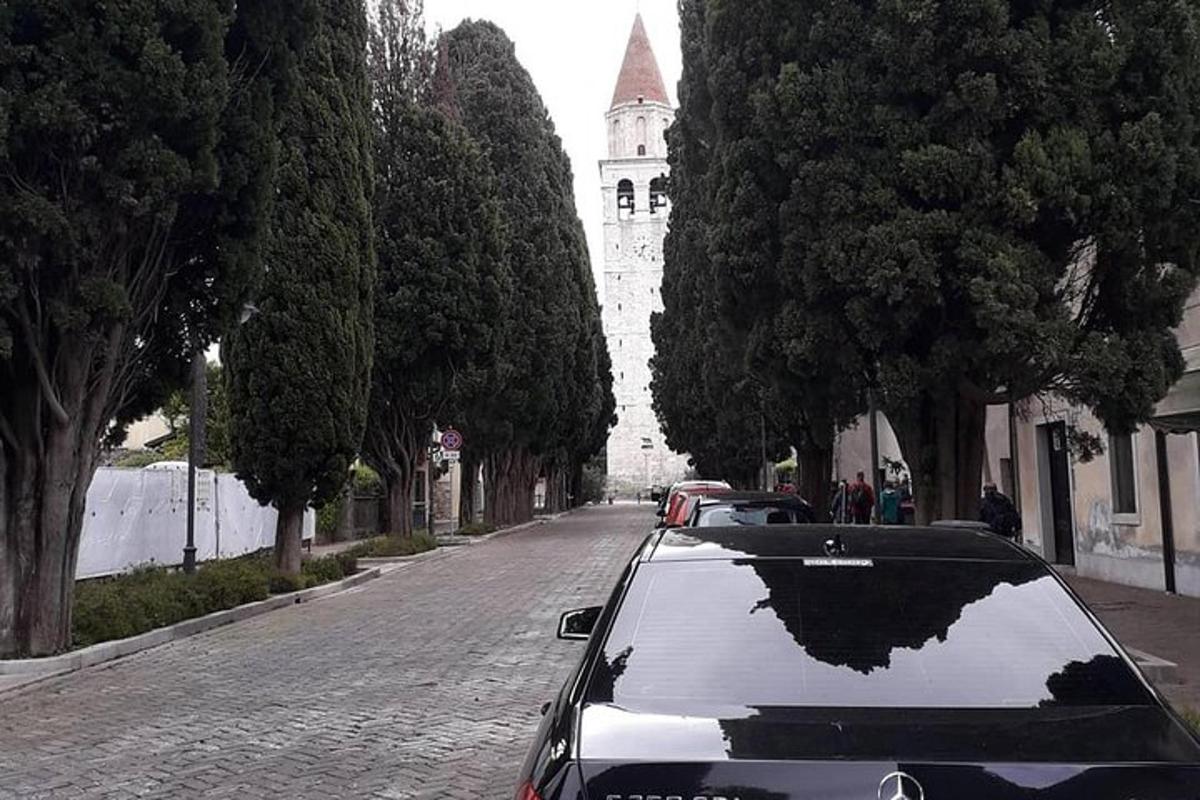 a car parked on a street with a reflection of a building