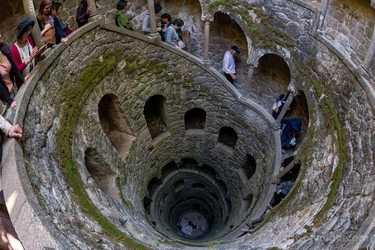 μια ομάδα ανθρώπων που περπατούν γύρω από μια πέτρινη σήραγγα
