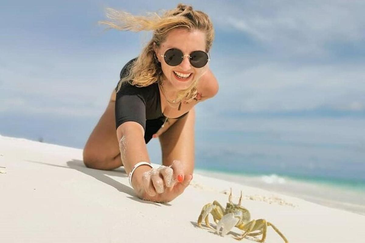 a woman laying on the beach next to a scorpion