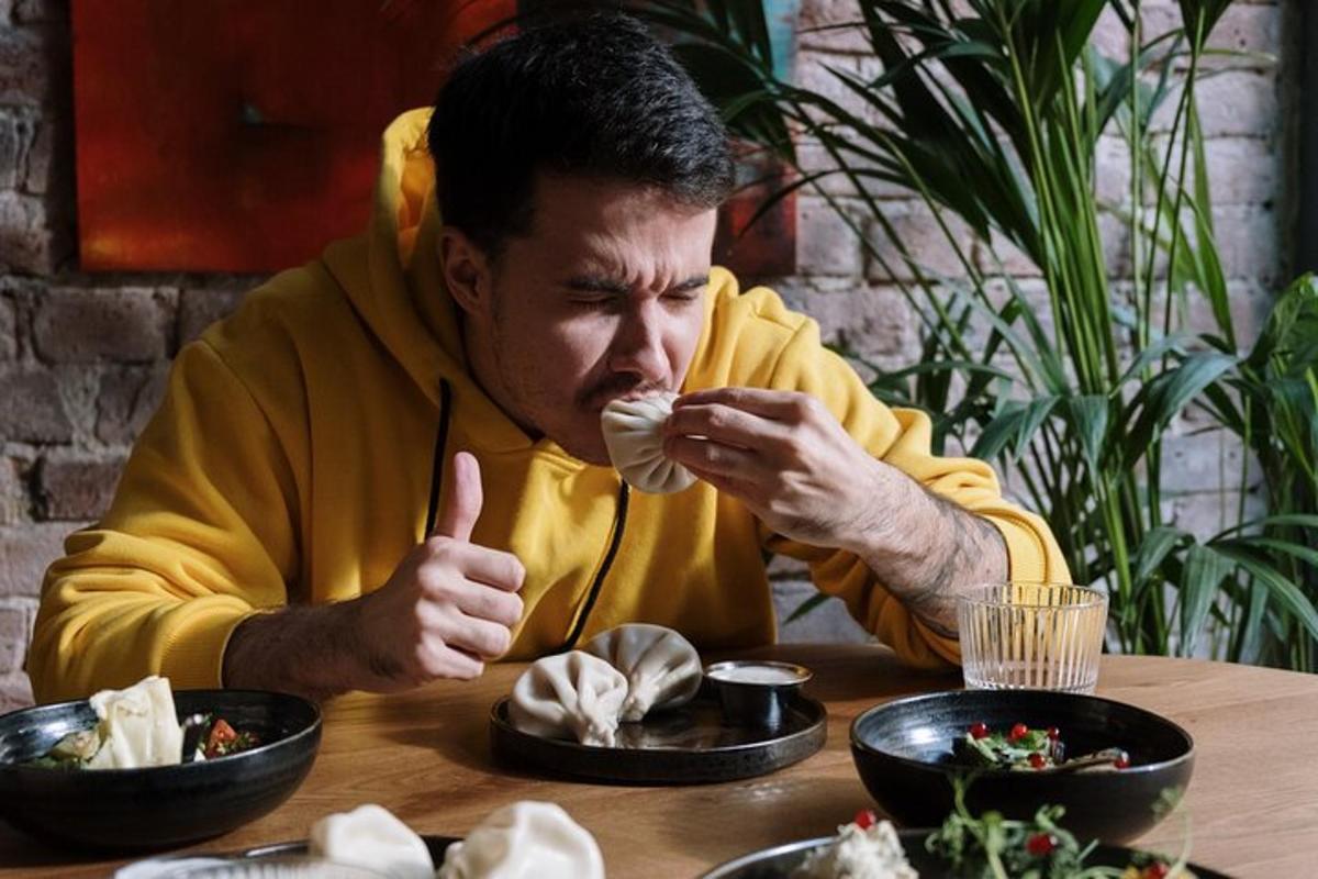 한 남자가 테이블에 앉아 음식을 먹고 있다