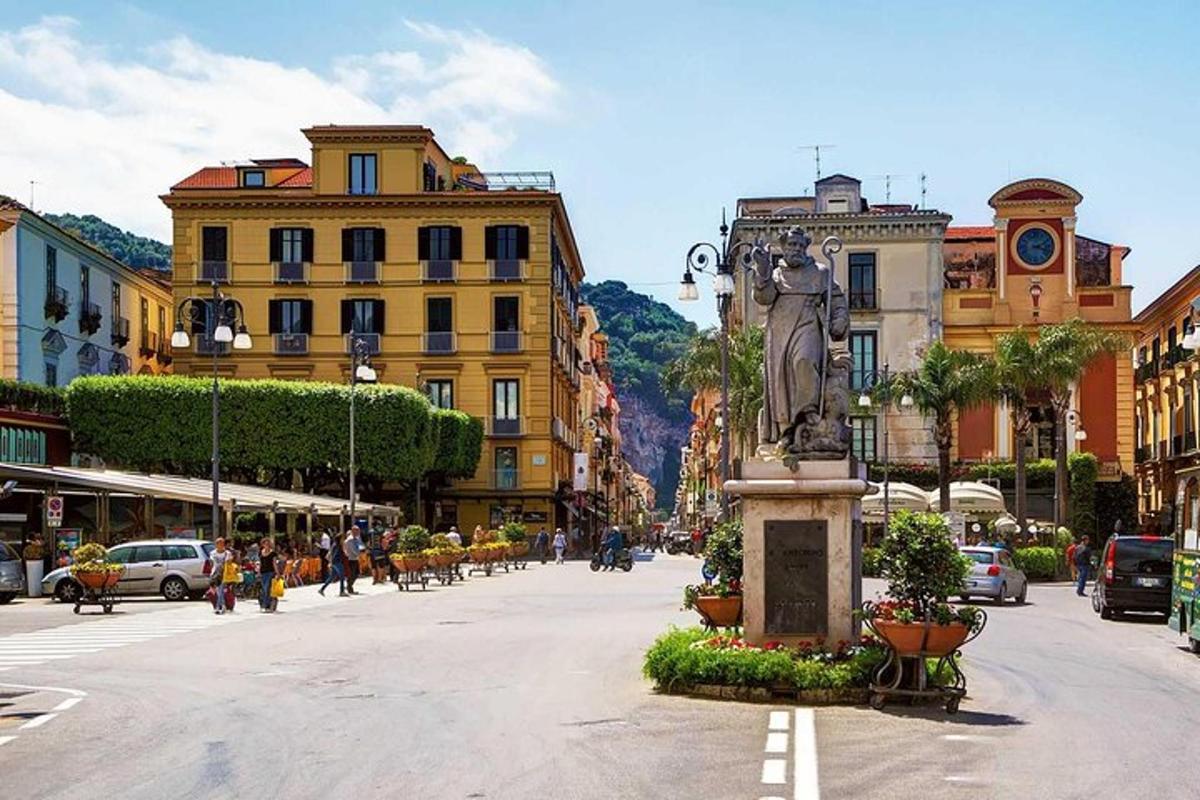 Una calle de la ciudad con edificios y una estatua en el medio.