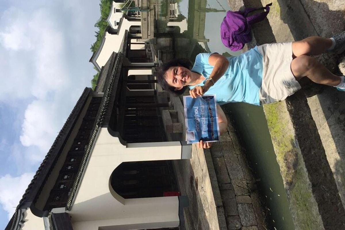 a woman standing on the side of a building with a book
