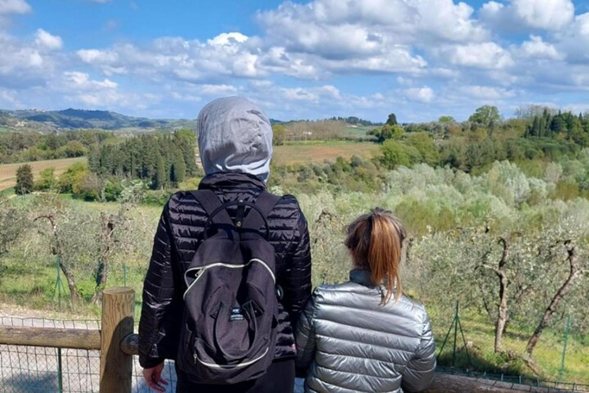 un uomo e una donna in piedi su una staccionata che guardano verso un campo