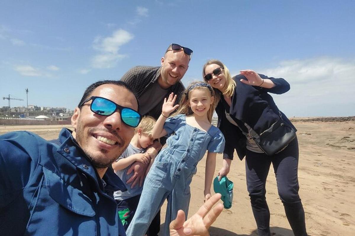 un grup de oameni care pozează pentru o fotografie pe plajă