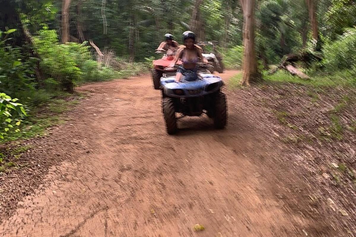 two people riding on a motorcycle on a dirt road