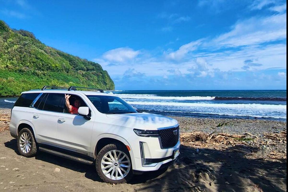 một chiếc xe SUV màu trắng đậu trên bãi biển gần đại dương
