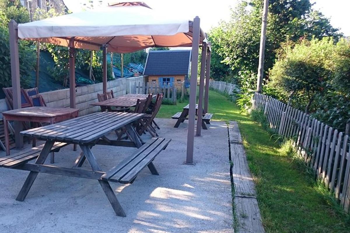 egy piknikasztal napernyővel egy kerítés mellett