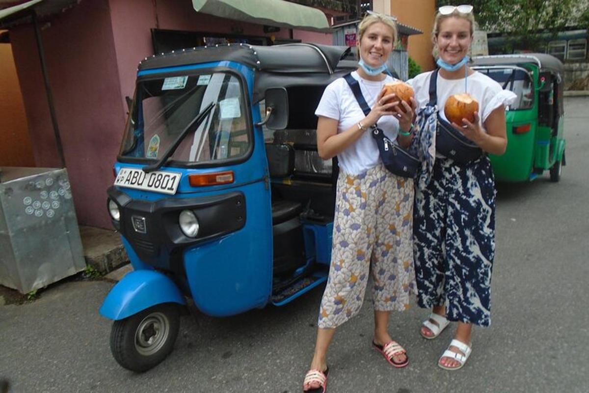 two women are standing next to a small motorcycle