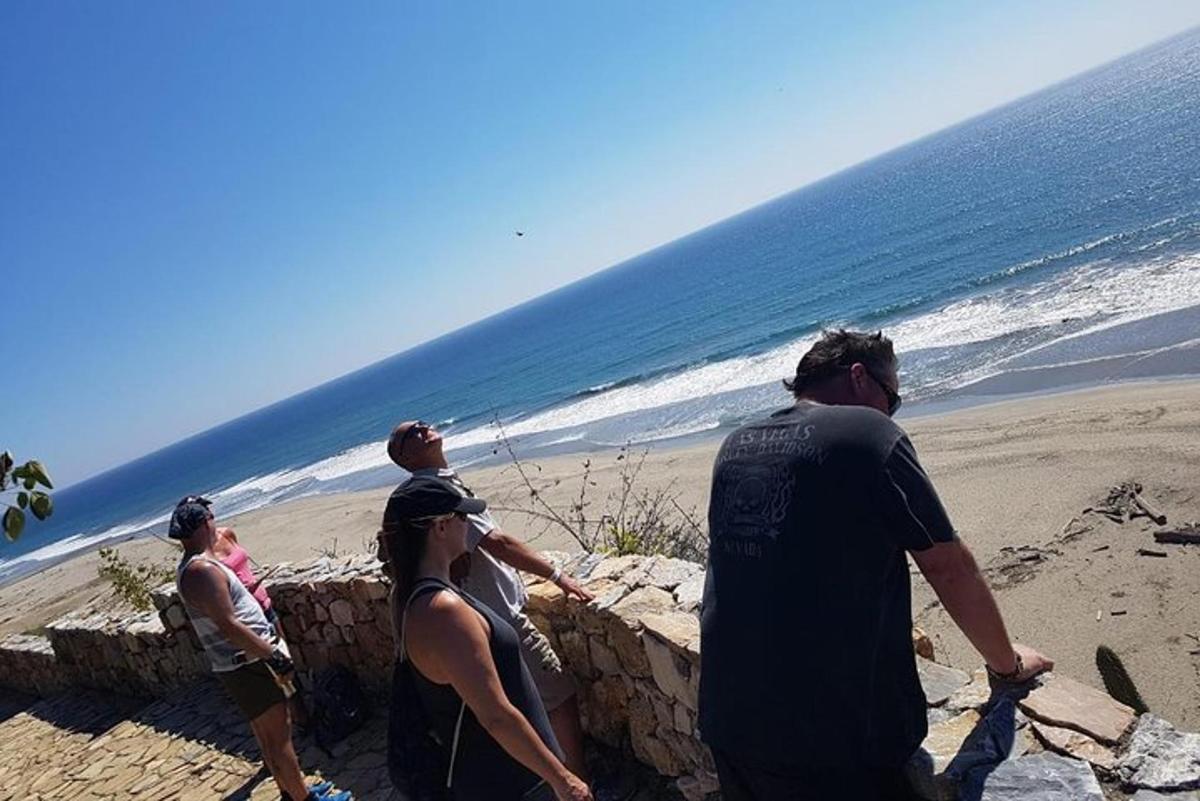 해변 근처 벽에 서 있는 사람들