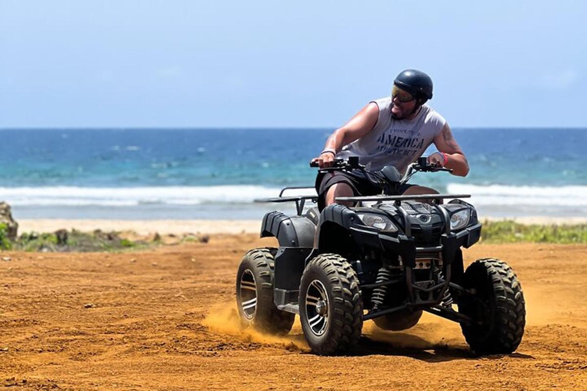 a man riding a four wheeler on the beach