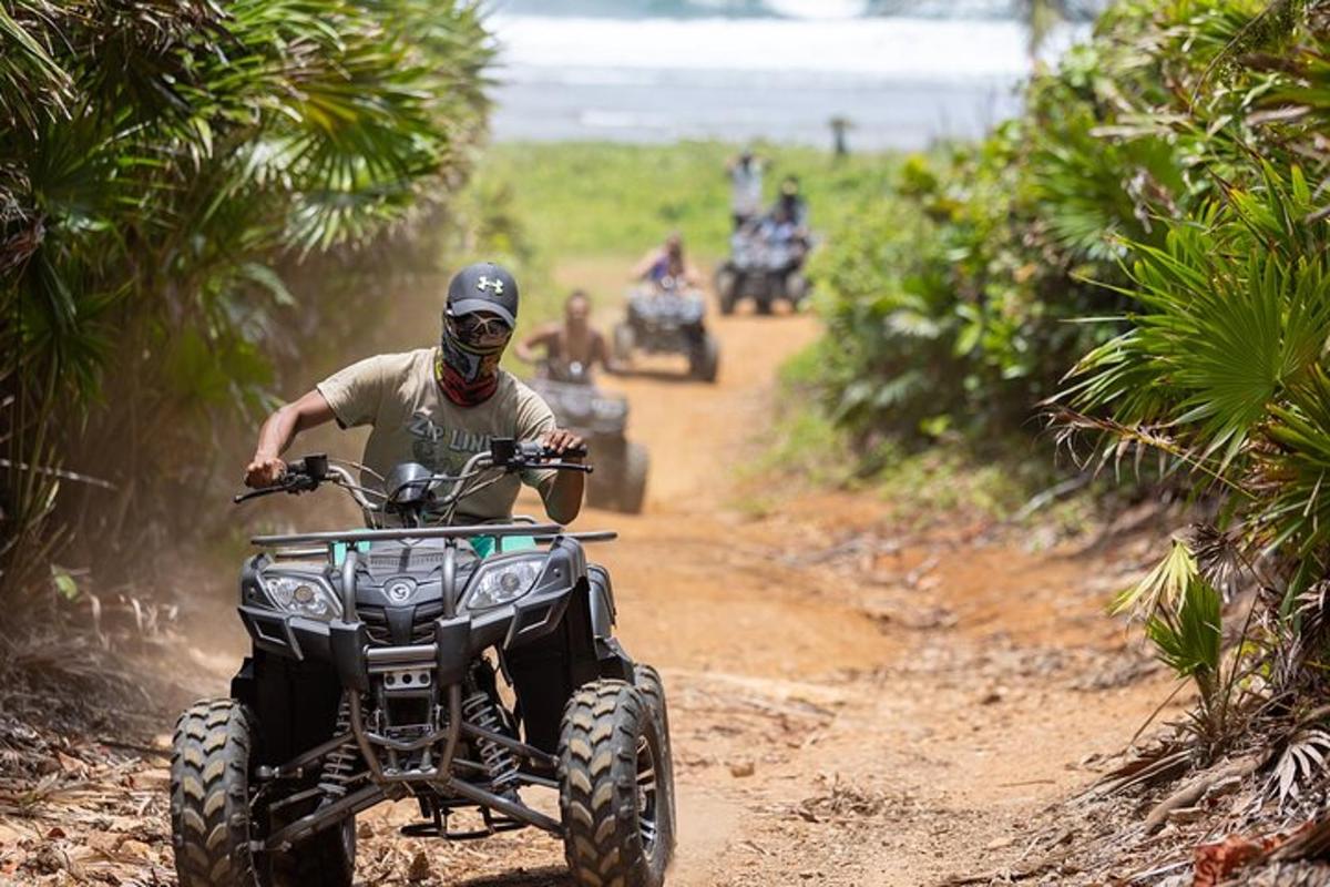 a man riding a four wheeler on a dirt road