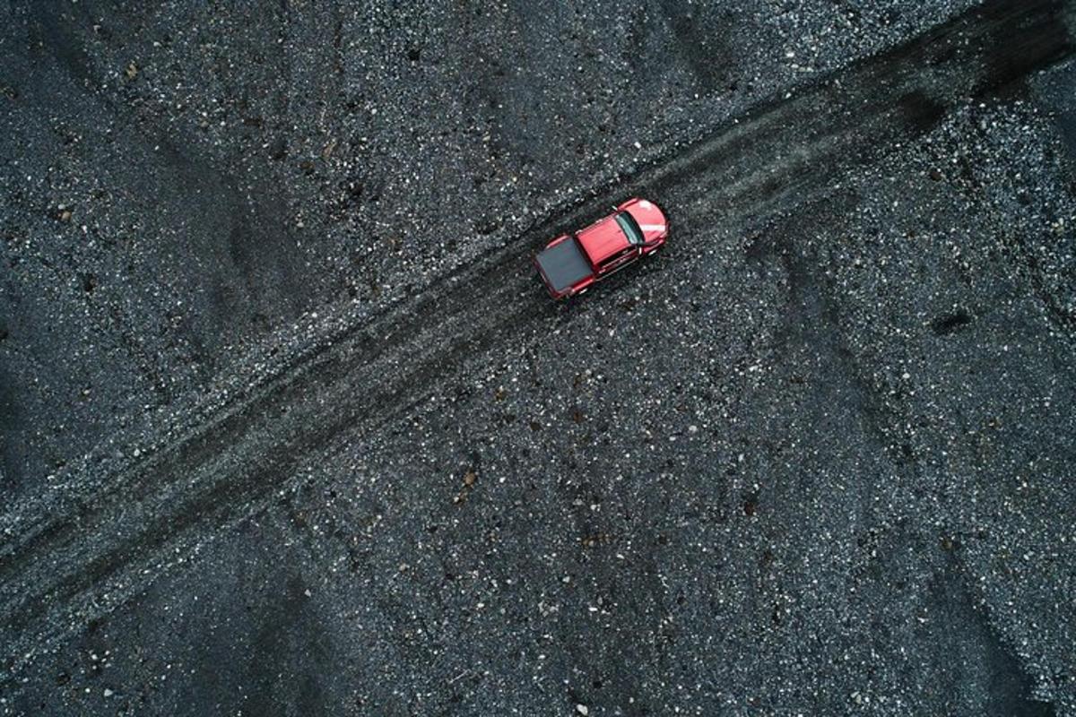 Ofanmynd af rauðum bíl á veginum