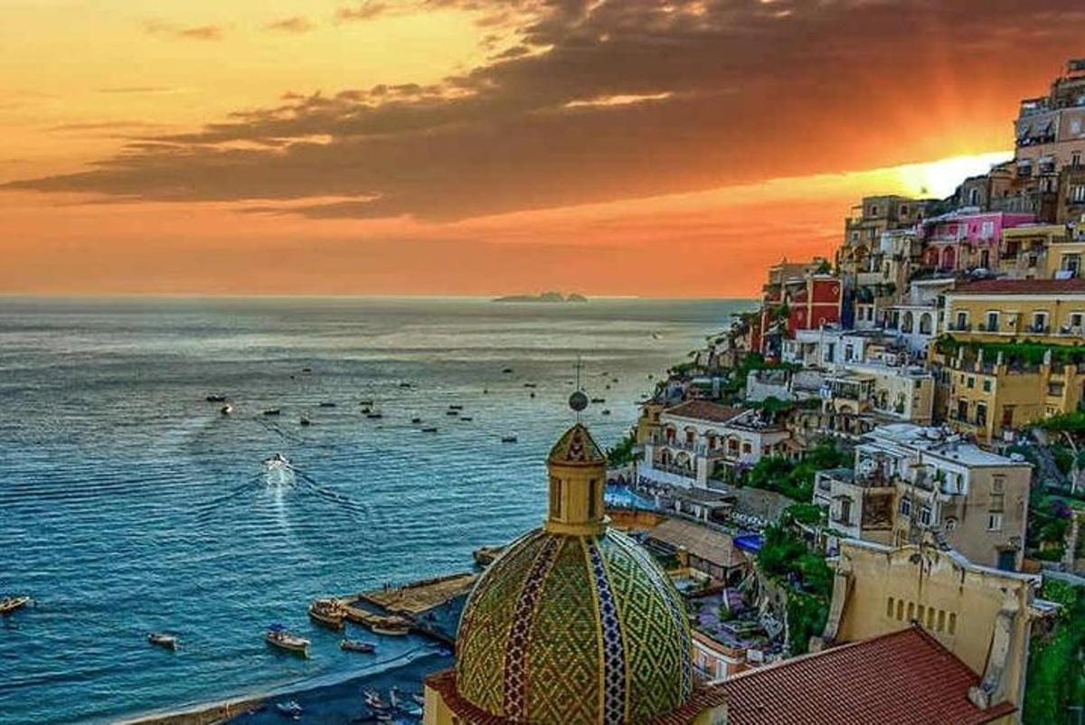 o vedere a unui oraș cu oceanul la apus