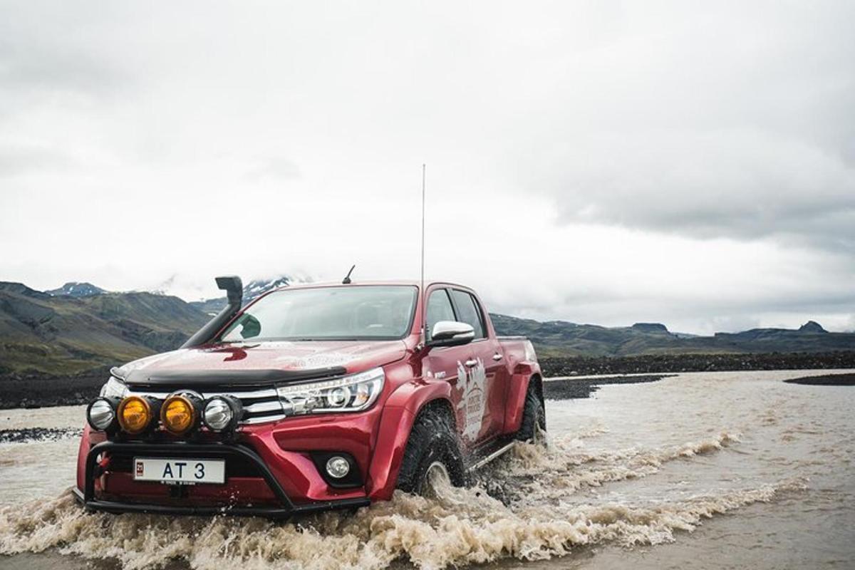 un camion rosso che attraversa l'acqua