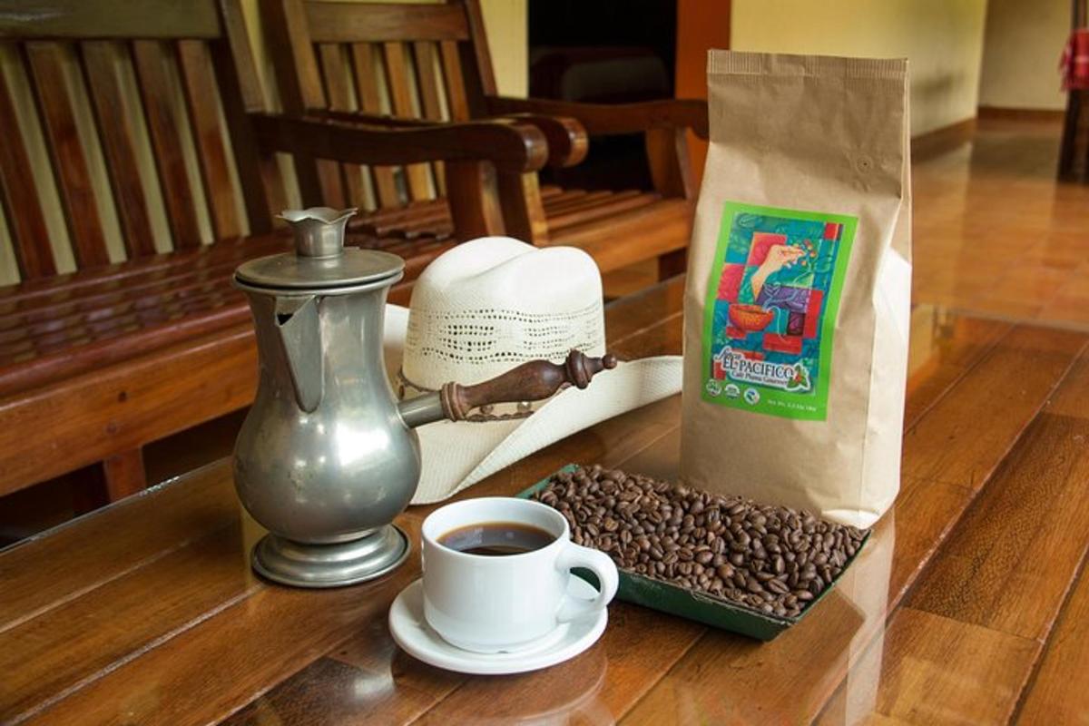 meja dengan secawan kopi dan beg biji kopi