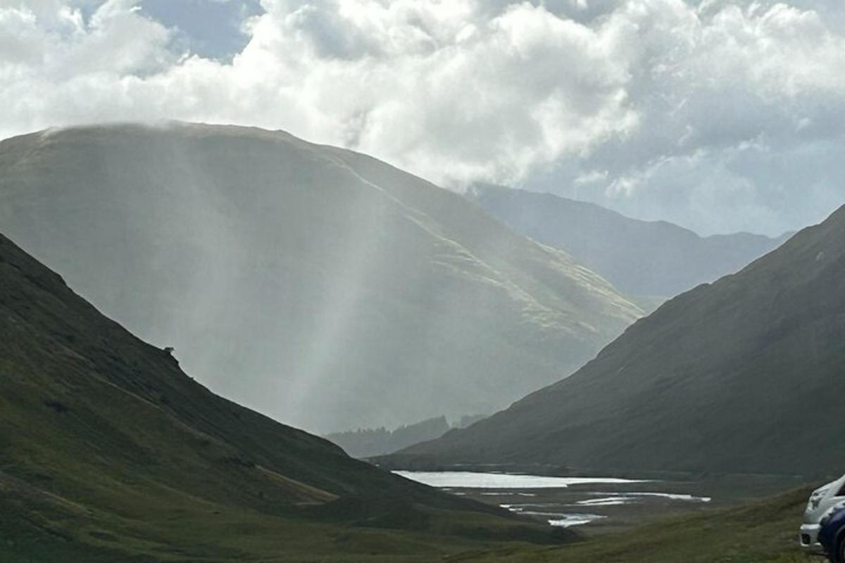 una vista di una valle con un fiume e montagne