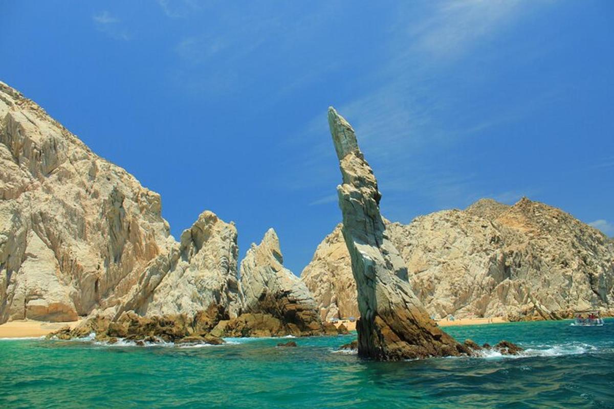 a rock formation in the water next to a beach