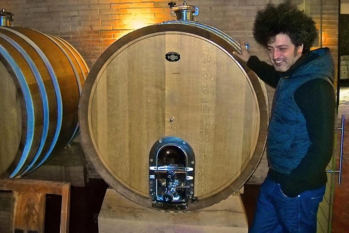 um homem está parado em frente a um barril