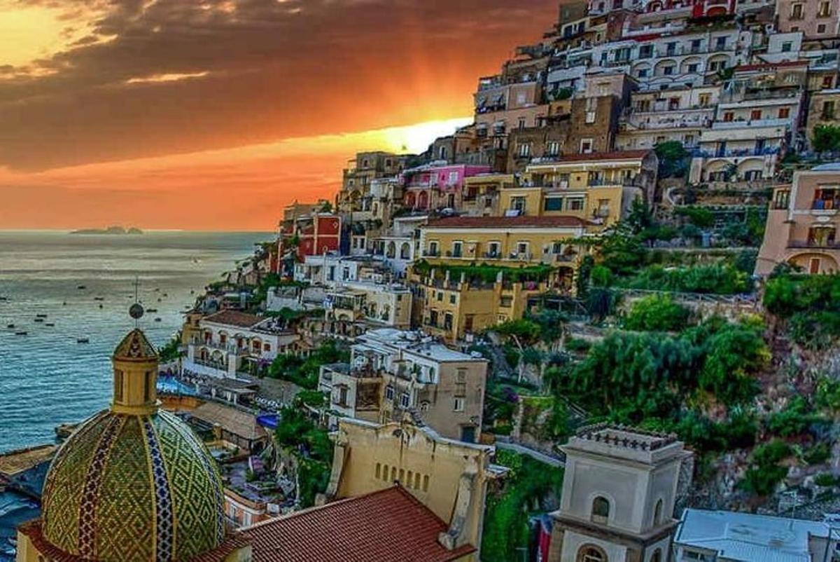 un gruppo di edifici su una collina con l'oceano