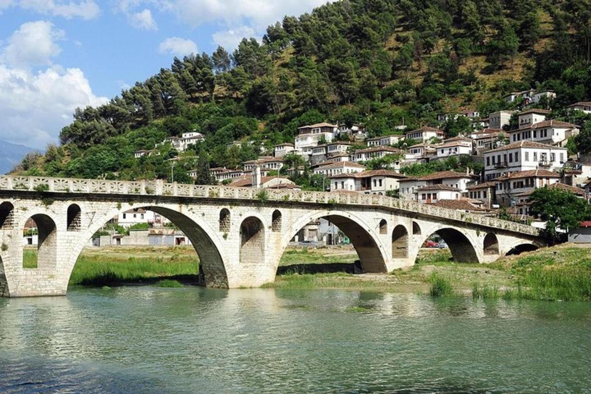 un ponte sopra un fiume di fronte a una montagna