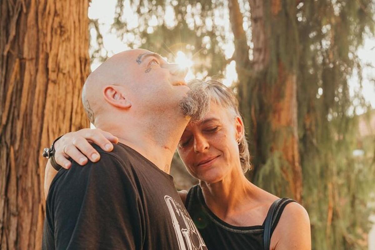 Un hombre y una mujer de pie junto a un árbol.