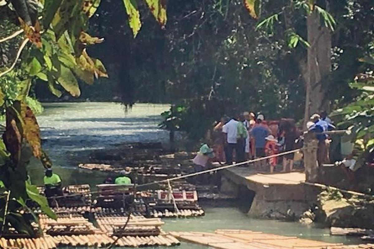 un gruppo di persone in piedi su un ponte sopra un fiume