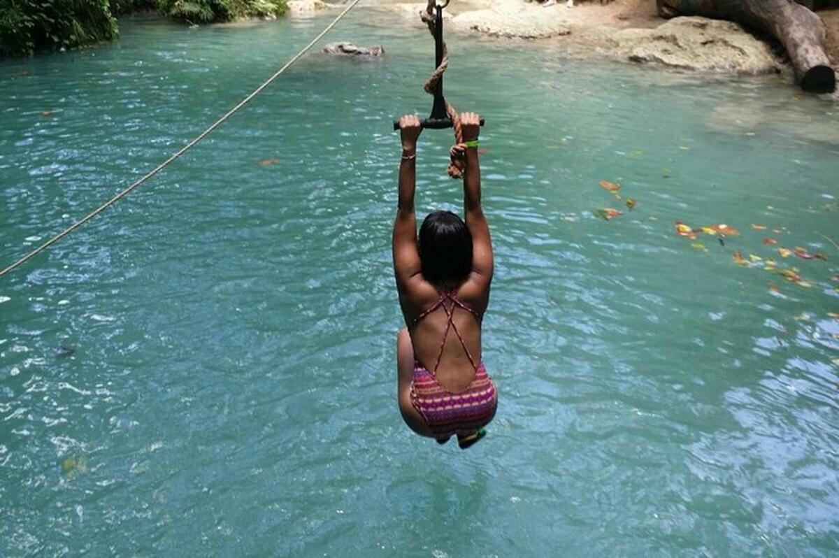 uma mulher pendurada em uma corda na água