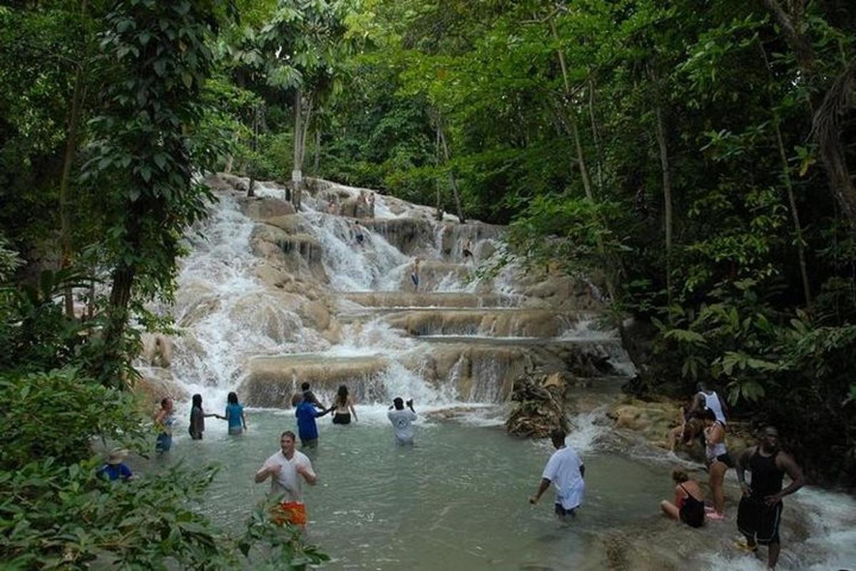 un gruppo di persone in acqua vicino a una cascata