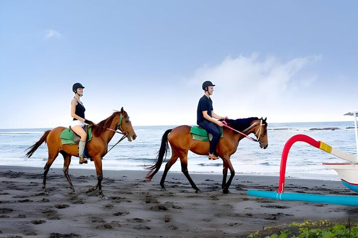 two people riding horses on the beach