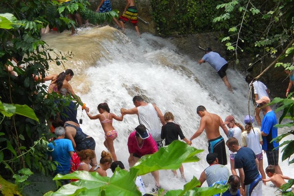 sekumpulan orang berdiri di dalam air terjun
