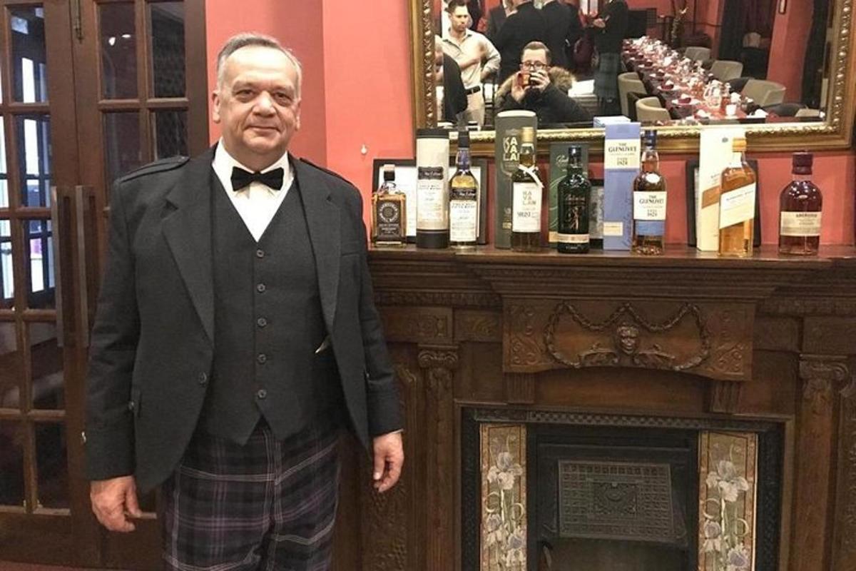 egy szmokingos férfi áll egy pult előtt