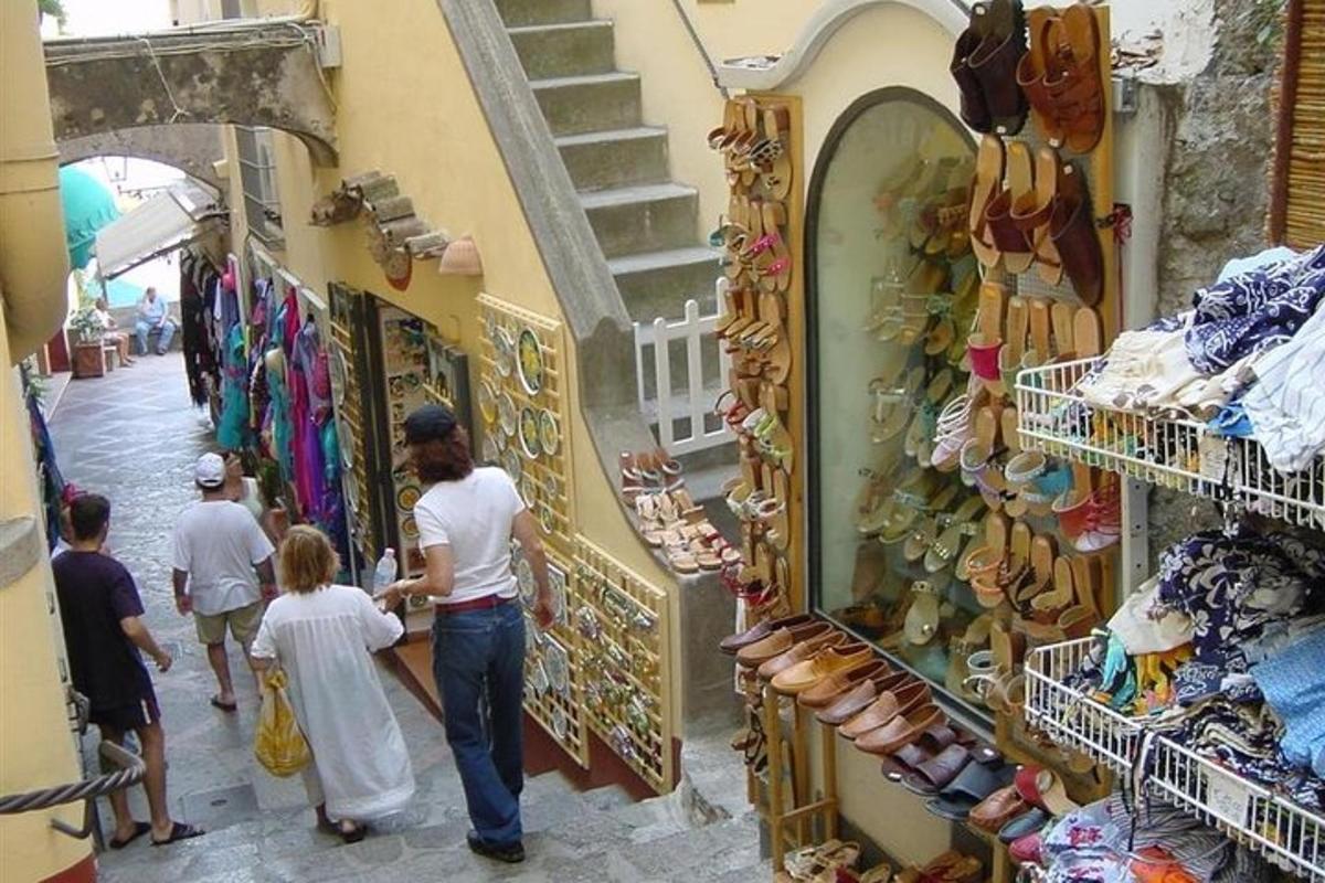 un grup de oameni care se plimbă printr-un magazin într-o piață
