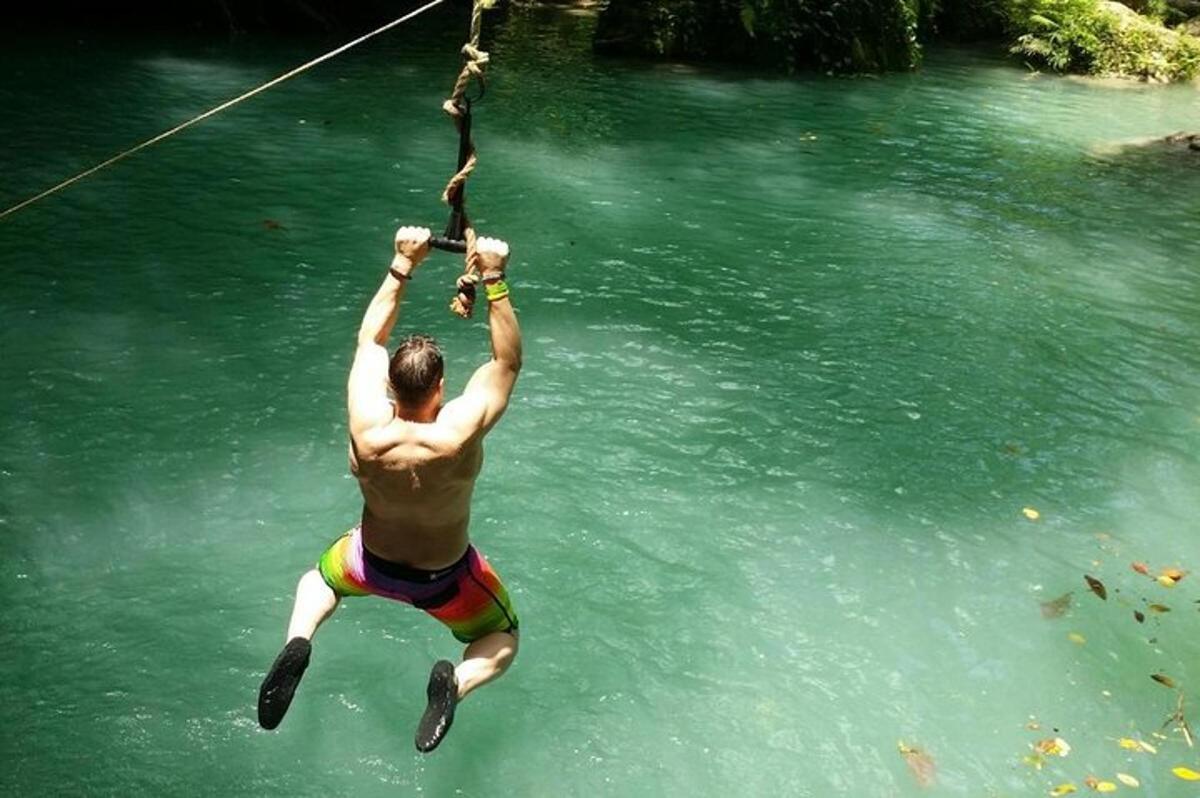 a man hanging from a rope in the water