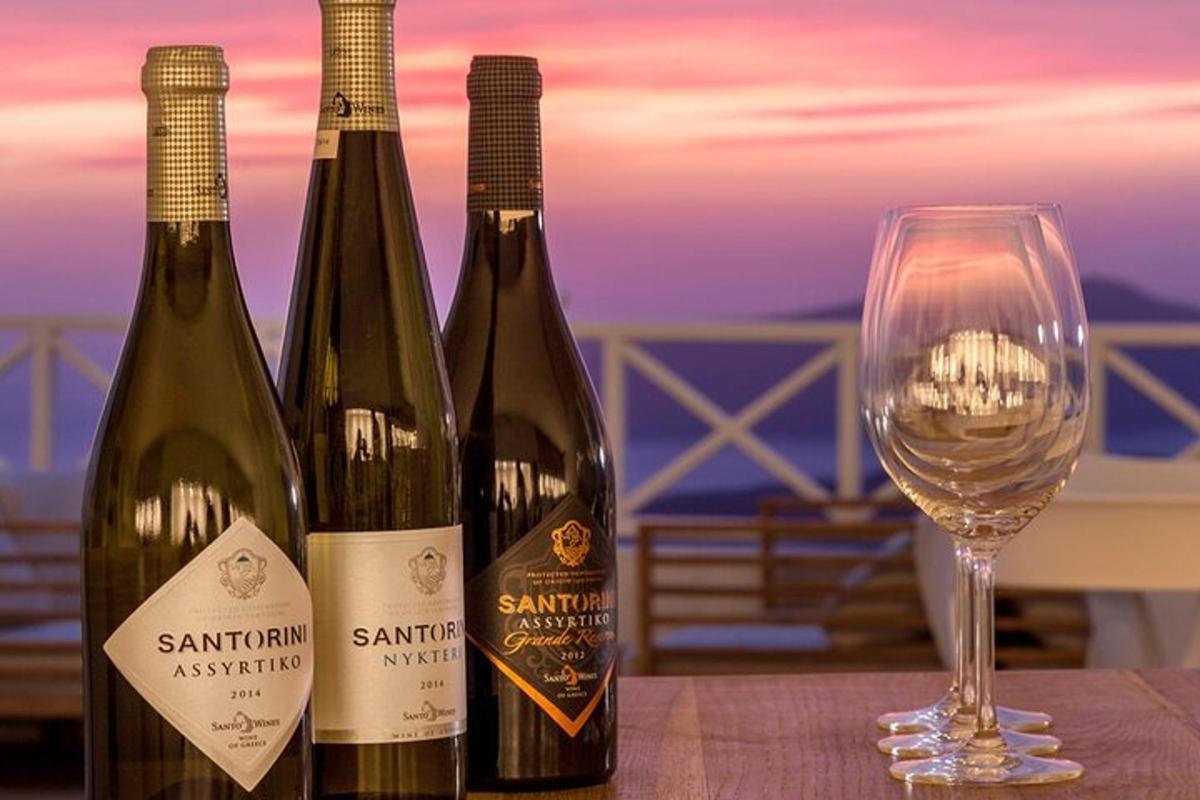 três garrafas de vinho ao lado de uma taça de vinho