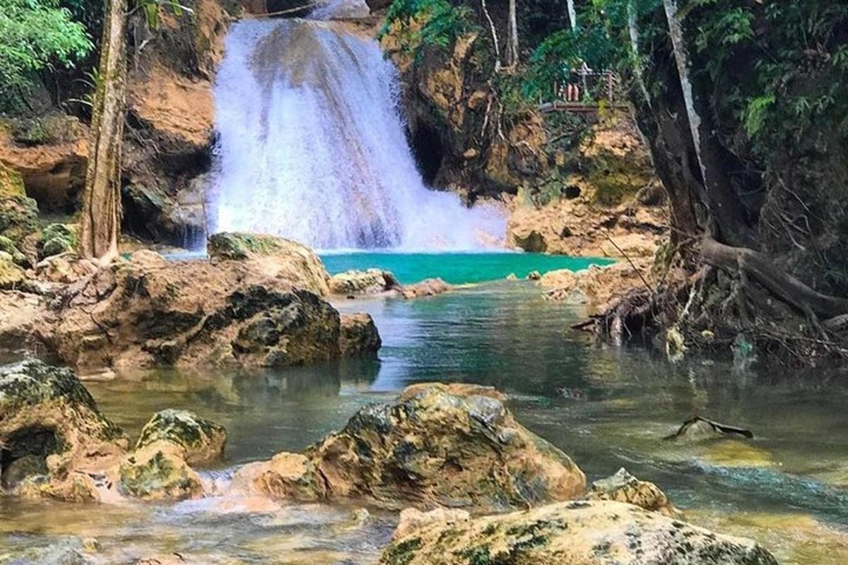 uma cachoeira em frente a uma piscina de água