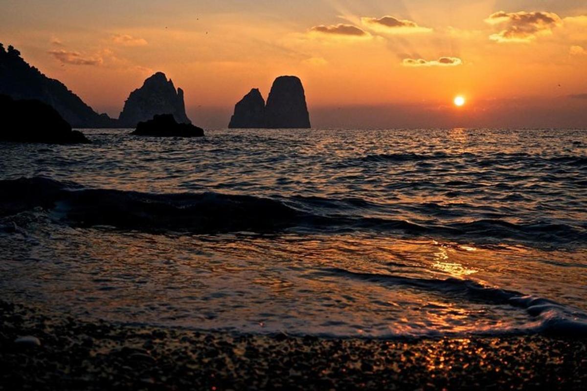 sončni zahod na plaži s skalami v vodi