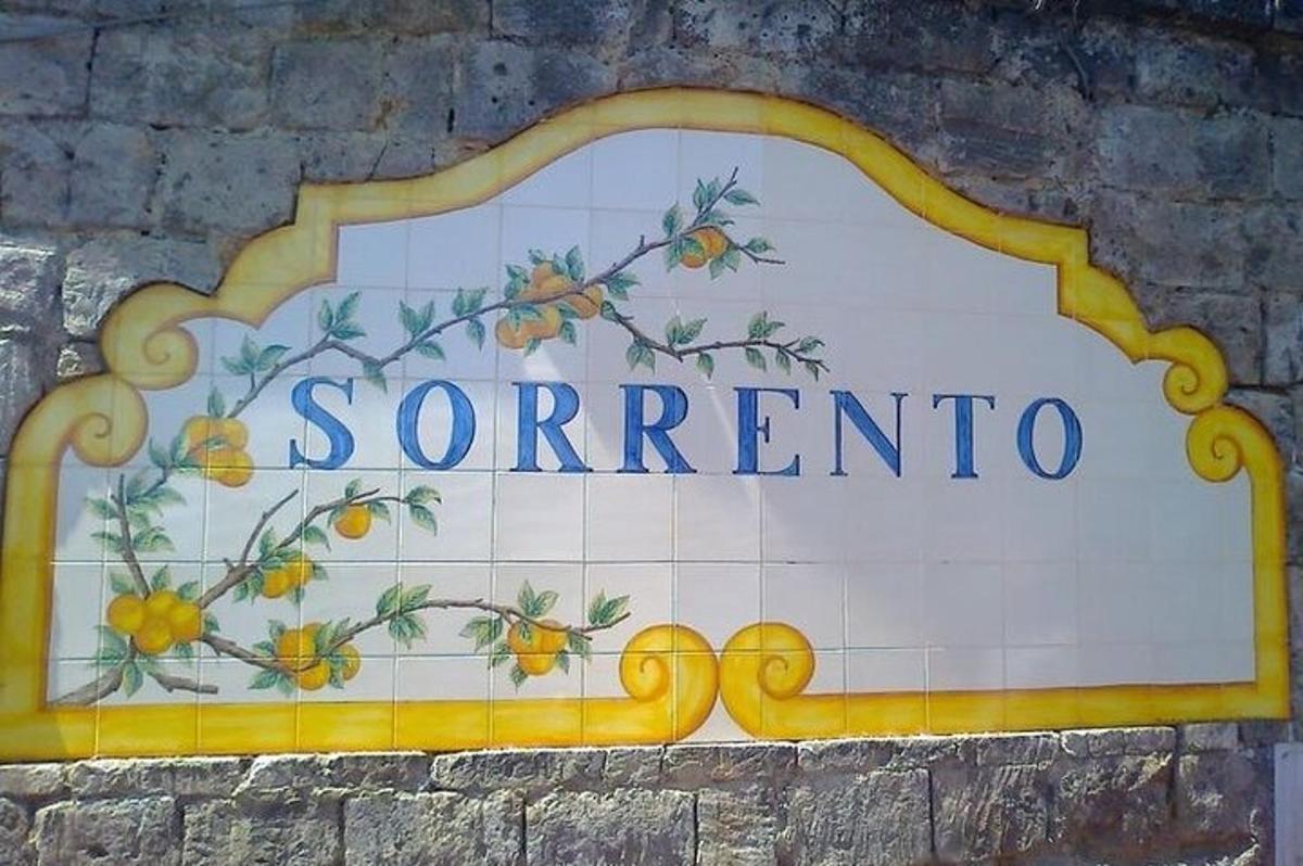 un cartello sul lato di un edificio con delle arance sopra