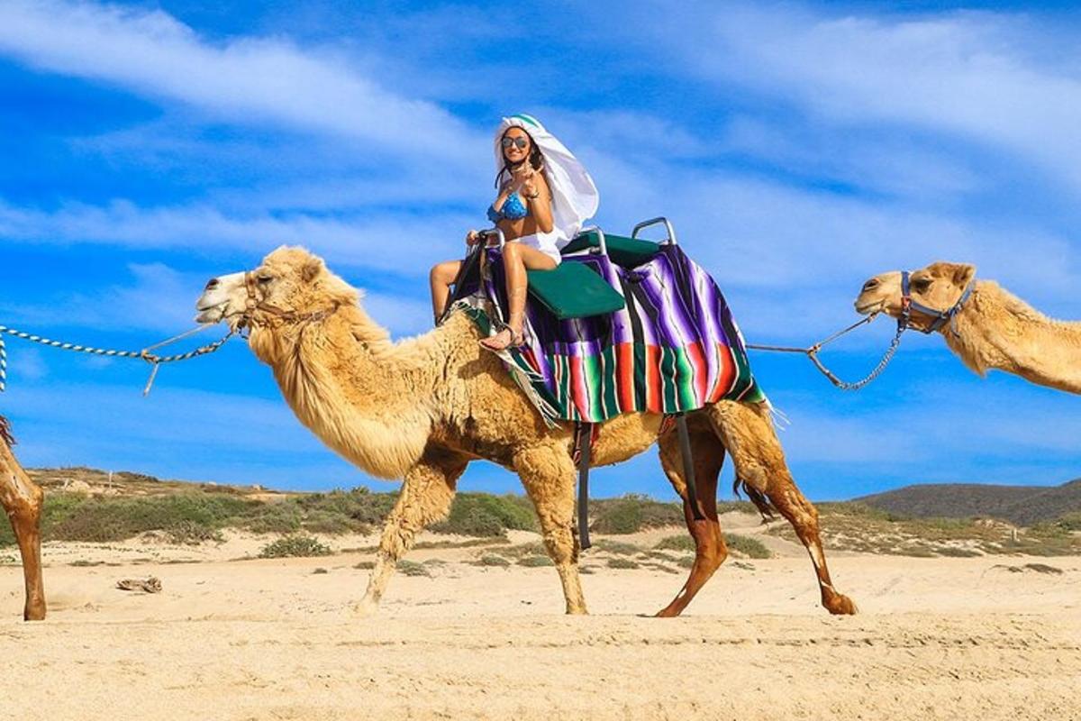 eine Frau, die auf einem Kamel am Strand reitet