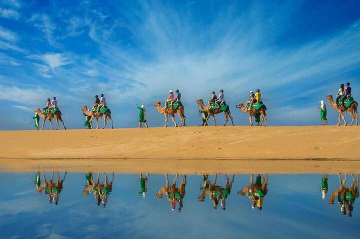 eine Gruppe von Menschen reitet am Strand