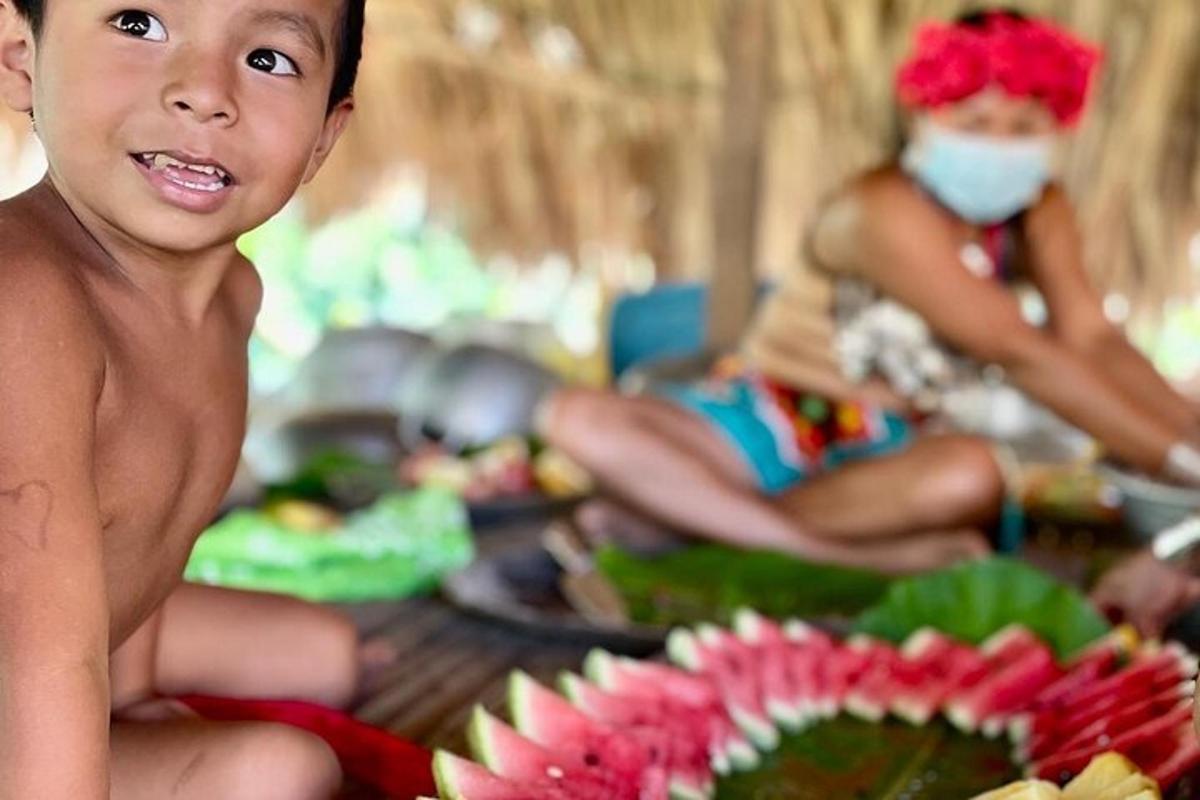 a young boy sitting on a table with flowers