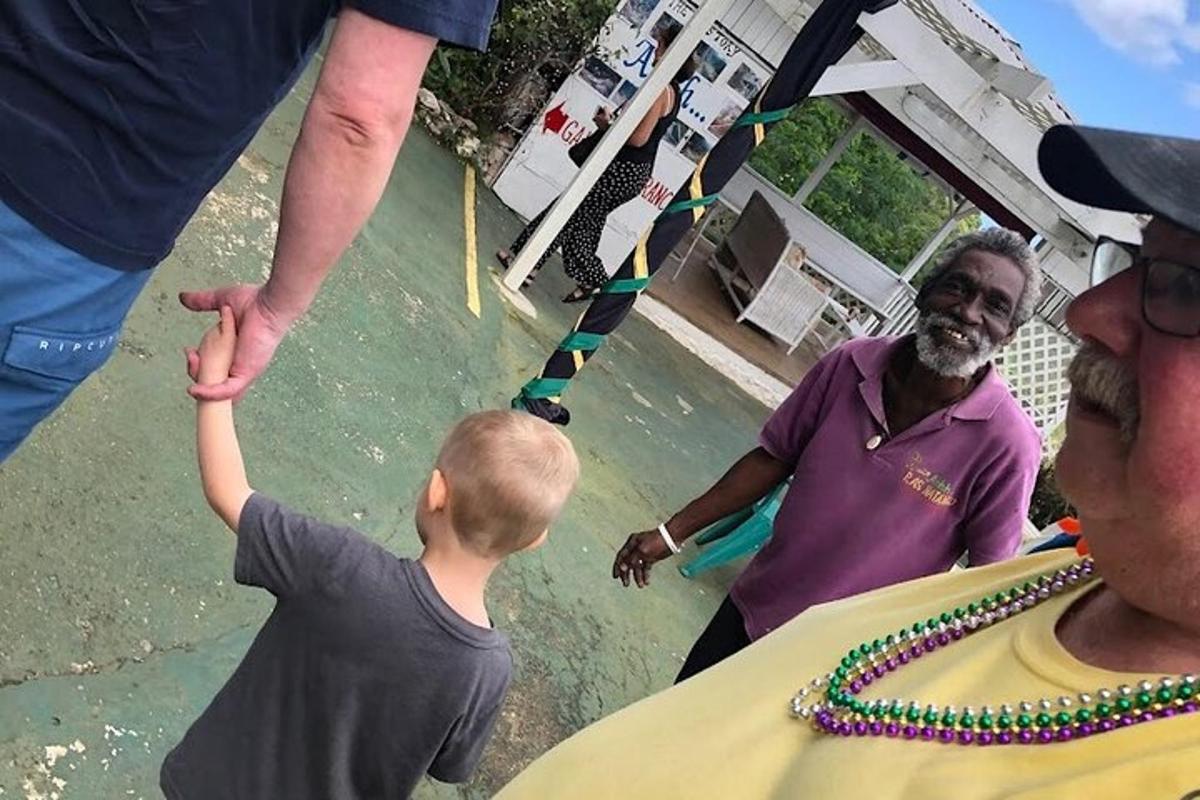 Ένα νεαρό αγόρι απλώνει το χέρι του προς έναν άντρα σε ένα τραπέζι