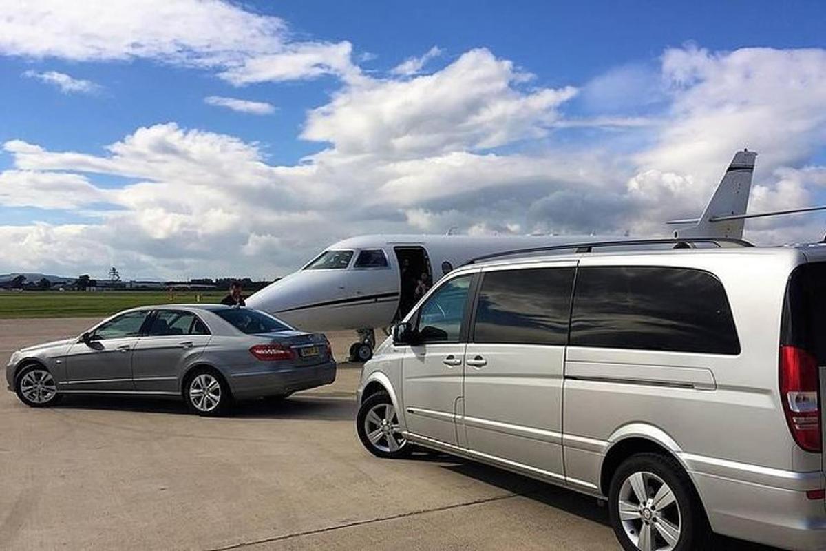 o dubă și o mașină parcate lângă un avion