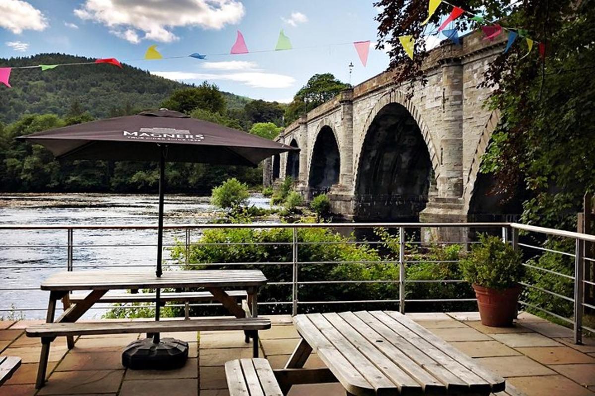 un tavolo da picnic con un ombrellone davanti a un ponte