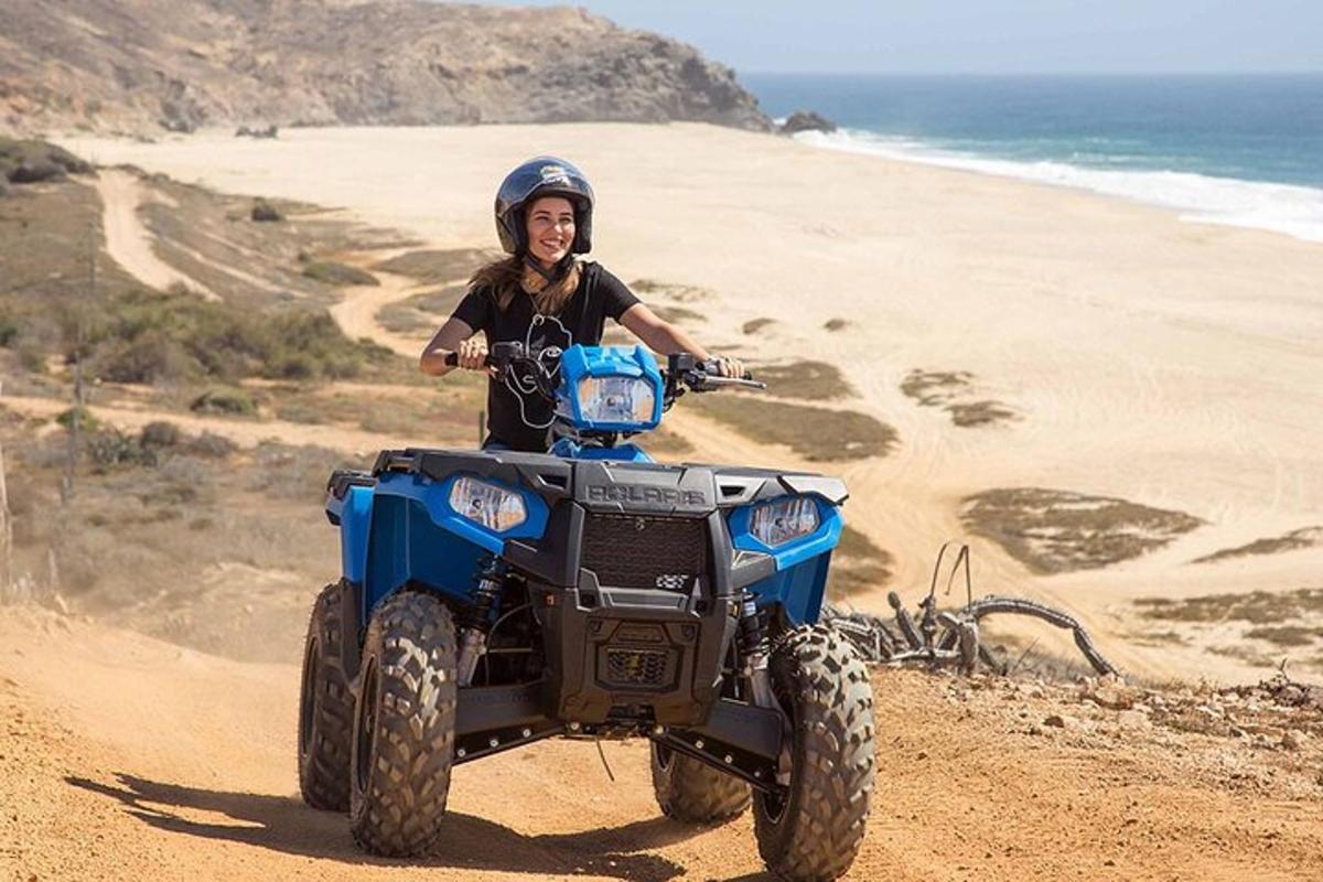 Un hombre conduciendo un vehículo todo terreno en la playa