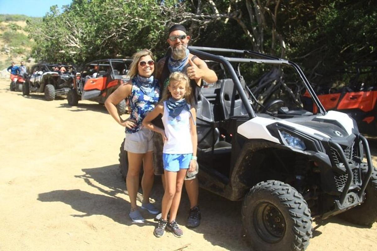 a man and two women standing in front of a jeep