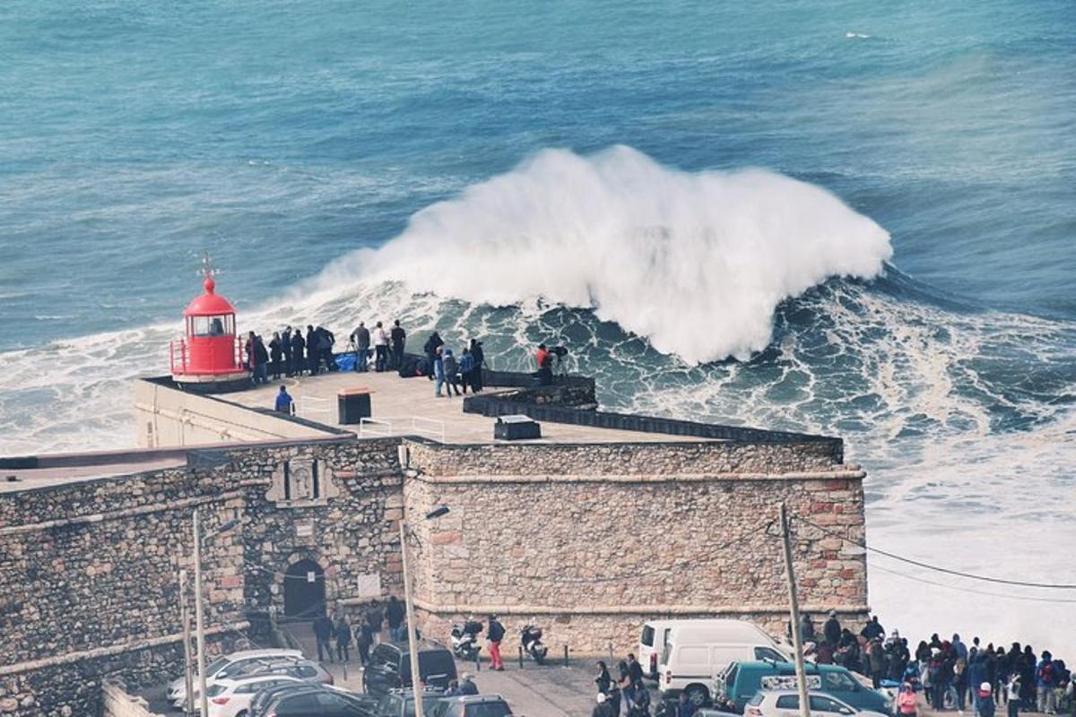 Una ola rompiendo contra un edificio con un faro