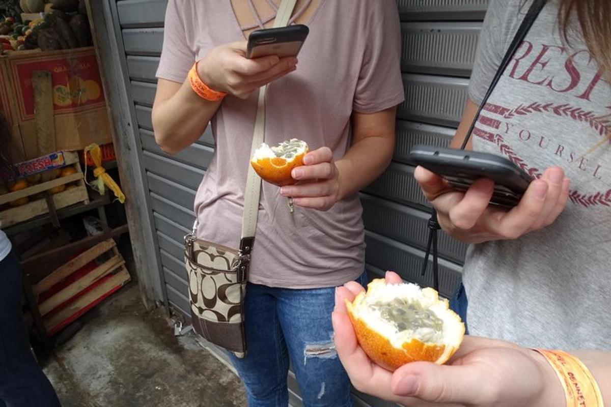 Dos personas sosteniendo teléfonos celulares y un perrito caliente.