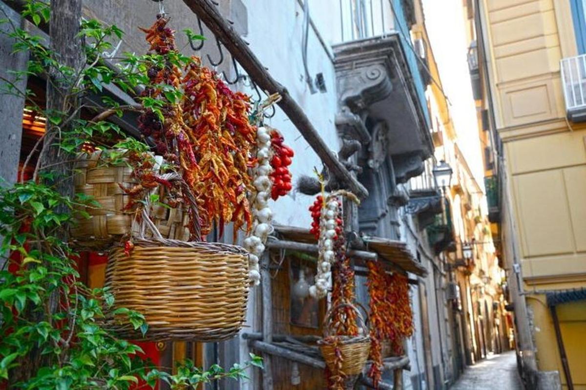 um beco com cestos e plantas na lateral de um prédio